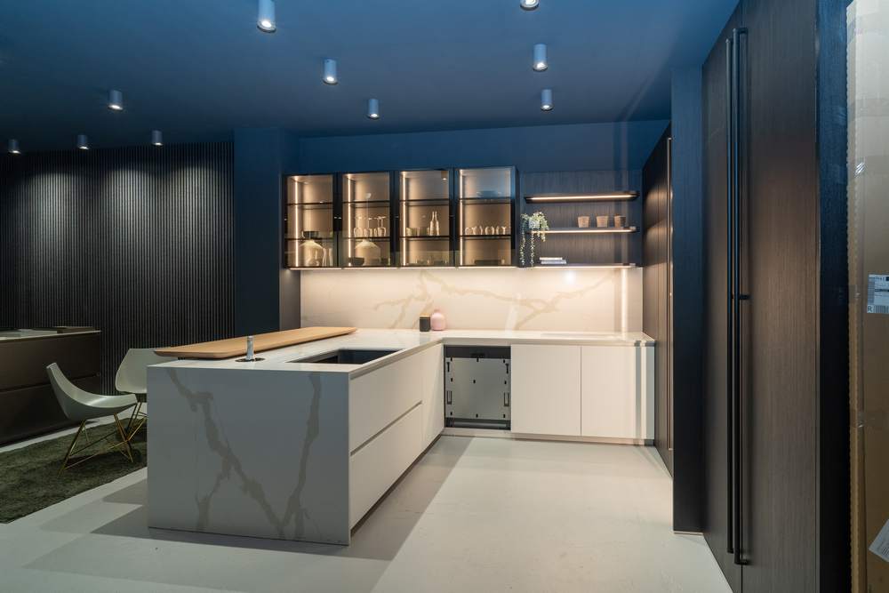 Ex Display Italian Luxury Ernestomeda One Fenix Bianco Kos Glass In Fume Rovere Blackwood Pocket Door Kitchen including Peninsular with Wooden Breakfast Bar – Bora Siemens Appliances - Stone Italiana Marmorea Golden Worktops