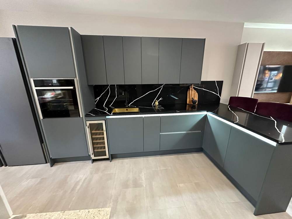 Ex Display Wolds Zola Matt Green Handleless Kitchen with Peninsula – Neff CDA 1810 Appliances – Black with White Marble Effect Quartz Worktops - 3832674