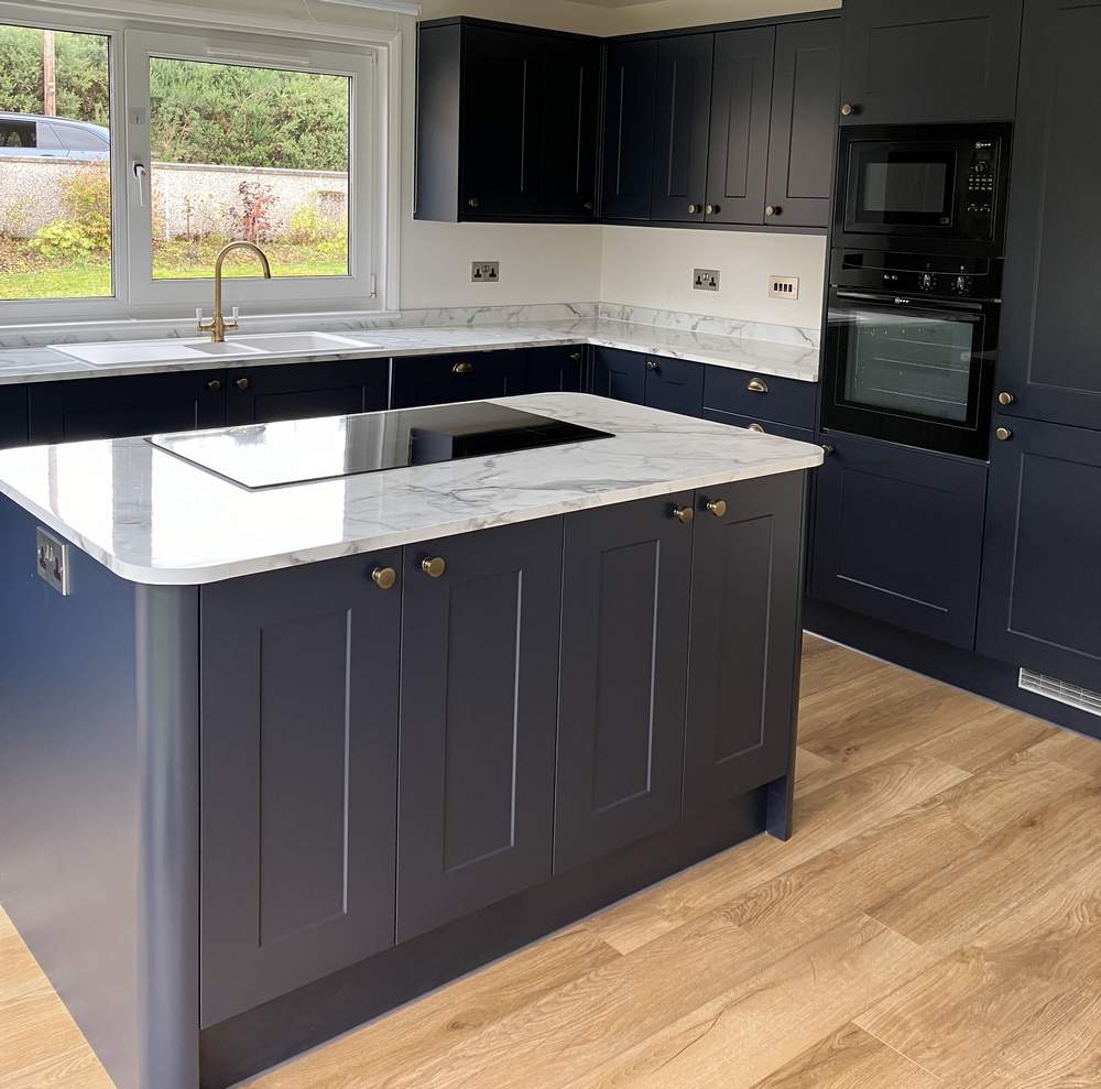 Young Howdens Dark Blue Shaker with Brushed Brass Handled Kitchen and Matching Island – Neff Lamona Appliances - Marble Effect Quartz Worktops